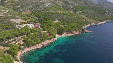 Uzak ve lüks deniz manzaralı evlerin kumlu kumsalları güzel kokulu çam ağaçlarının altında gizlidir. Sahildeki evlerin altında turkuaz Adriyatik Denizi 'ne bakan küçük bir sahil manzarası..