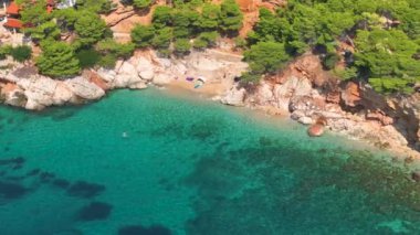 Yaz güneşinin tadını çıkaran turistlerle birlikte Hvar adasındaki tenha bir körfezin üzerinde uçmak. Akdeniz adasının uzak bir köşesindeki kumlu bir kumsalın gizli bir mücevherinin insansız hava aracı görüntüsü..