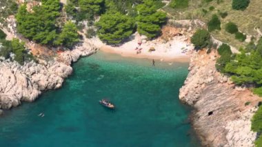 Yaz tatilinin tadını çıkaran rahat turistler Hvar adasındaki ıssız bir kumsalda eğleniyorlar. Turkuaz Adriyatik denizi ve gür Hırvat kıyı şeridinin çarpıcı hava manzarası.