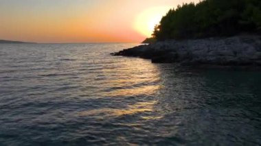 Adriyatik Denizi 'nin sakin sularının altın saatinde nefes kesici manzarası. Güneşli bir yaz akşamında Hvar adasının engebeli bir sahili. Gündoğumunda Dalmaçya 'daki Idyllic Adası.