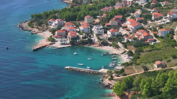 エリアル 風光明媚なクロアチアの島のビーチフロントハウスの下の小さな港の景色のショット 地中海の海岸線に沿って飛行し ハヴァル島の遠隔地にある眠った海辺の村 — ストック動画