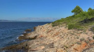 Adriyatik adası Hvar 'ın engebeli ve ıssız bir sahil şeridinde uçuyoruz. Ufukta görünen büyük bir ada daha. Dalgalar yemyeşil çalılarla güneşli kayalara vuruyor..