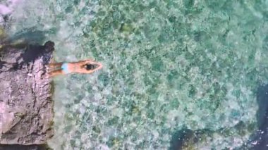 AERİAL, SLOW Motion, TOP Down: Atletik genç kadın, Hvar 'da eğlenceli bir yaz tatilinin tadını çıkarırken kristal berrak denize balıklama atlıyor. Adriyatik 'in ferahlatıcı denizi yaz güneşinde parlıyor.