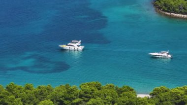 İki lüks yat Hvar adasının manzaralı kumsalları boyunca yelken açıyor. Akdeniz 'deki bir takımadayı keşfetmek için iki lüks tekne boyunca uçuyorlar. Adriyatik 'teki deniz kıyısının insansız hava aracı görüntüleri