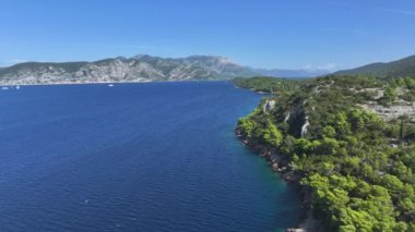 Adriyatik adası Korcula 'nın engebeli kayalık kıyı şeridi boyunca uçuyor. Uçsuz bucaksız mavi deniz ufukta ve vahşi takımadaların arasında uzanır. Korcula 'nın uzak kısmının çekimleri.