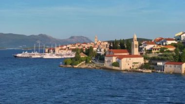 Altın akşam güneşi, tarihi Korcula adasını aydınlatıyor. Gün batımında Korcula 'nın pitoresk eski kasabasının manzaralı görüntüsü. Adriyatik 'te nefes kesici bir kasaba manzarası.