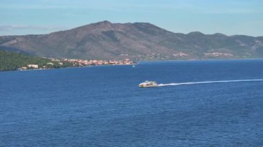 Büyük katamaran, çarpıcı Korcula adası yakınlarındaki derin mavi Adriyatik Denizi 'ne yelken açıyor. Hırvatistan 'da güneşli bir yaz gününde Akdeniz' de toplu taşımacılık yapan bir katamaranın insansız hava aracı görüntüsü.