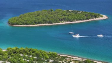 Akdeniz adası yakınlarında demirli bir yelkenlinin yanından yat yolculuğu yapıyor. Dalmaçya 'da güneşli bir günde birkaç tekne küçük adaların etrafındaki suları keşfediyor. Hırvatistan kıyılarında dolaşmak.