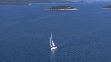 Lüks yelkenli, güneşli bir günde Adriyatik 'in sakin sularını keşfeder. Murter Adası yakınlarındaki manzaralı sularda yüzen yelkenli görüntüsü. Dalmaçya 'da eğlenceli yaz tatili aktivitesi.