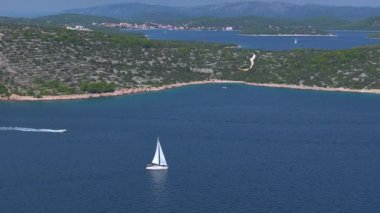Güneşli bir yaz gününde, Adriyatik Denizi 'ni keşfeden bir yelkenliyle hızlı bir tekne hızlanır. Hırvatistan 'ın Dalmaçya kentinde derin mavi sularda yüzen teknelerin panoramik manzarası.
