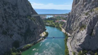 Her iki nehir kıyısındaki yüksek kayalık kayalıkları olan yemyeşil bir nehir vadisi boyunca boş bir tekne dolaşır. Güneşli bir günde Zümrüt Cetina nehri boyunca yelken açar. Hırvatistan 'ın doğal güzelliği.