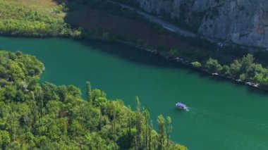 Göz kamaştırıcı zümrüt renkli Cetina nehri boyunca gezici tur tekneleri yelken açıyor. İki turist teknesi Cetina 'da manzaralı bir yaz yelkenlisinde buluşuyor. Hırvatistan 'ın Dalmaçya kentinde nefes kesici bir su yolu.