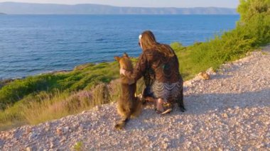 Gece boyunca Adriyatik Denizi manzaralı turist ve kano sahipleri. Hanımefendi güzel köpeğiyle güzel vakit geçiriyor ve yaz tatilinin tadını çıkarıyor. Hvar adasında.