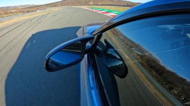 Zaman deneme yarışında yüksek performanslı bir arabayla dolambaçlı bir pistte yarışmak. Metalik mavi spor araba kapalı bir yarış pistinin keskin virajlarında uçsuz bucaksız kurak araziyle çevrilidir.