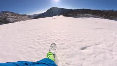Manzaralı kış harikalar diyarı güneşli bir Aralık gününde kar kazıyan snowboardcuların etrafını sarıyor. Slovenya 'nın kırsal kesimindeki karlı tepeden aşağıya pudra panosuyla inerken çekilen ilk kişi..