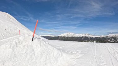 Genç erkek snowboardcu bir vurucuya biniyor ve harika bir yakalama numarası yapıyor. Yüksekten uçan snowboardcu boş kar parkında bir numara yapıyor. Erkek turist parkta snowboard yapıyor..