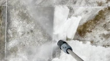 Kirli fayansları yıkayan basınç temizleme ekipmanlarına yakından bakın. Duvardaki eski toprağı temizleyen su spreyi. Yüksek basınçlı çamaşır makinesi gri taş kiremitleri temizler ve kirletir..