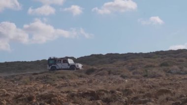 Off-road car is driving on a dusty Cyprus road