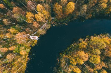 Aerial view of blue winding river and fall forest with autumn colorful trees. Beautiful nature landscape in Finland