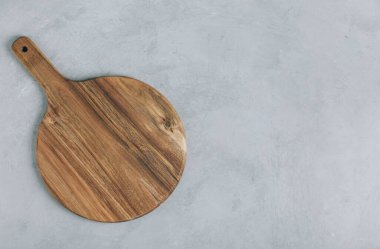 Kesme tahtası. Gri taş zemin üzerinde boş yuvarlak tahta kesme tahtası, üst görünüm, boşluk kopyala.