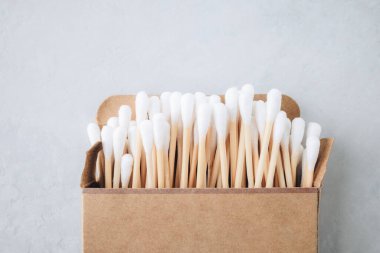 Bambu kulak çubukları. Gri arka planda çevre dostu pamuklu çubuklar, üst manzara, kopyalama alanı. Biyo-çözünebilir tahta çubuklar temizleyici kulaklar için. Sıfır atık, plastiksiz, sürdürülebilir yaşam tarzı konsepti