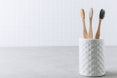 Eko diş fırçaları. Bambu diş fırçaları gri taş arka planda, kopyalama alanı. Asgari banyo arkaplanı