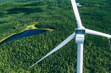 Windmills, wind turbines. Aerial view of windmills in green summer forest in Finland. Wind turbines for electric power with clean and Renewable Energy clipart