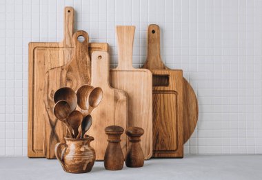 Mutfak aletleri arka planda tahta kesme tahtaları, sürahi ve tuz ve biber karışımı kaşıklar, kopyalama alanı