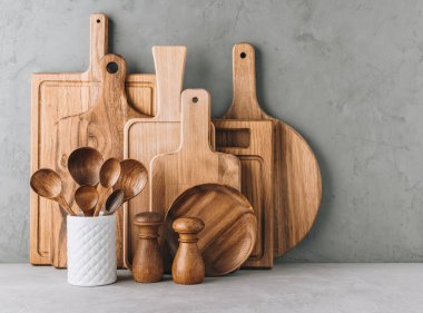 Mutfak aletleri arka planda tahta kesme tahtaları, sürahi ve tuz ve biber karışımı kaşıklar, kopyalama alanı