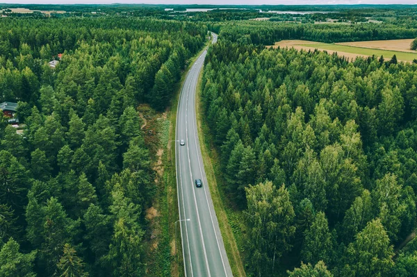 フィンランドの緑の夏の森を介して車とアスファルトの道路の空中ビュー — ストック写真
