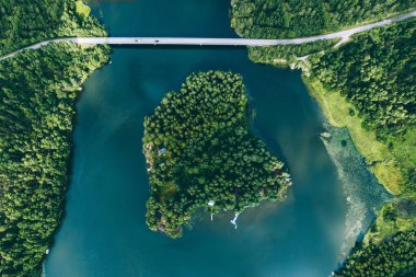 Mavi su gölü üzerinde arabalı köprü yolu manzarası veya Finlandiya 'da yaz aylarında ada ve yeşil ormanlı deniz manzarası.