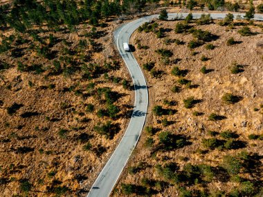 Çöl manzaralı dolambaçlı yol ve beyaz araba, drone manzaralı.