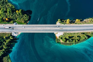Mavi ve turkuaz su nehir okyanusu arasında asfalt köprü yolunun hava manzarası. İnanılmaz yaz manzarası..