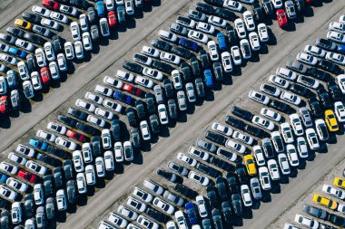 Otoparkın hava aracı görüntüsü. Yeni araba deposu. Birçok araba arka arkaya park etmiş ve satışa ve dağıtıma hazır..