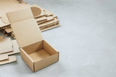 Karton kutu. Kahverengi karton kutu. Gri arka planda kahverengi karton kutu, içi boş. Hediye ve teslimat için kare karton kutu