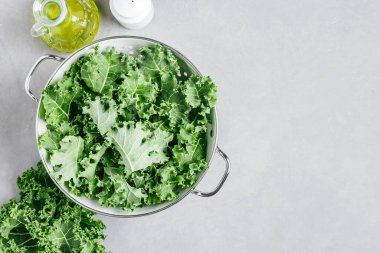 Kıvırcık Kale. Gri taştan arka planda kevgir şeklinde taze doğranmış kıvırcık kale. Lezzetli sağlıklı salata, vejetaryen yemeği, süper yemek için hazırım..