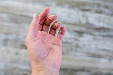 Ahşap bir yüzey üzerinde kadın eli.