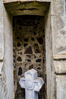 Eski bir haç, duvar teneffüsü, taşlar..