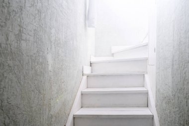 Beyaz ahşap bir merdivenin sonundaki ışık..