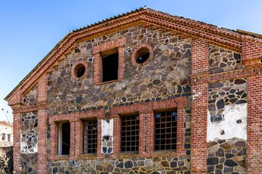 Eski bina, değirmen. Taş, tuğla. Kırık camlar, güneşli bir gün.