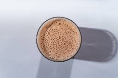 En üst cam manzaralı beyaz masada tatlı var.