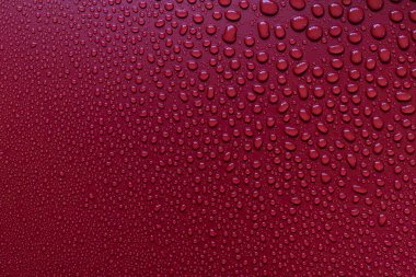 damlacıklarla kırmızı ıslak yüzey 