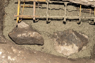 Çelik destekli parmaklıklar. Temelde bağlı tel ve ıslak beton var. İnşaat alanında inşaat iskeleti ve çimento karışımının yakın çekimi. İnşaat mühendisliği ve inşaat endüstrisi 