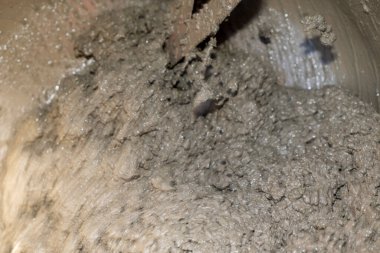 Sert desenli ve küçük taşlı ıslak gri çamur. Doğal çamurlu yüzeyin makro görüntüsü.