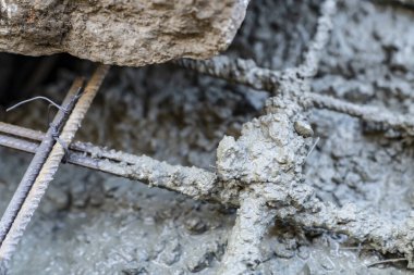 Çelik destekli parmaklıklar. Temelde bağlı tel ve ıslak beton var. İnşaat alanında inşaat iskeleti ve çimento karışımının yakın çekimi. İnşaat mühendisliği ve inşaat endüstrisi 