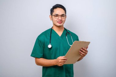 Neşeli, dost canlısı Asyalı erkek doktor, günlük kontroller sırasında dosyasıyla doktor, izole edilmiş beyaz arka planda duruyor.