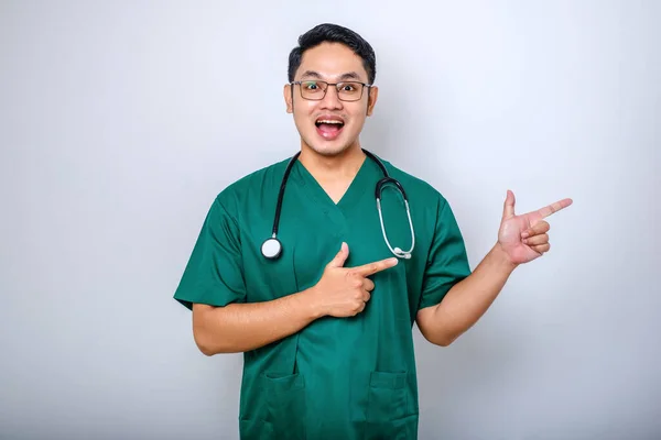 Lachende Knappe Aziatische Arts Verpleegster Scrubs Stethoscoop Wijzende Vingers Rechter — Stockfoto