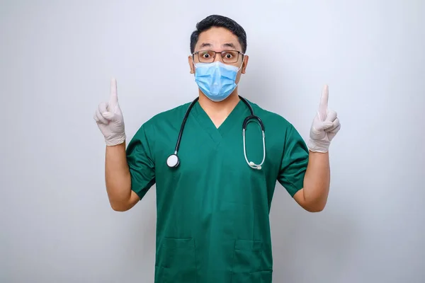 Verrast Nieuwsgierig Mannelijke Verpleegster Groene Scrubs Medisch Masker Wijzende Vingers — Stockfoto