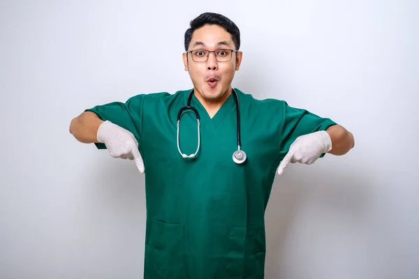 Geschokt Verrast Aziatische Mannelijke Verpleegkundige Arts Groene Scrubs Wijzend Vingers — Stockfoto