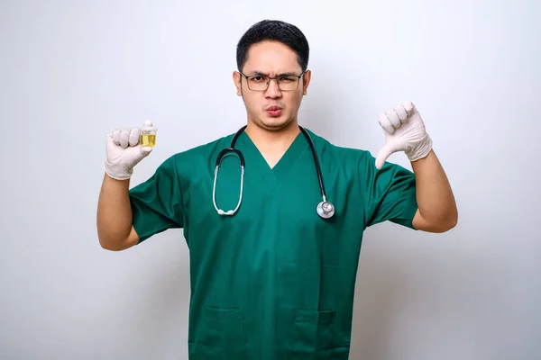 Ciddi Bir Asyalı Doktor Başparmağını Aşağı Gösterirken Idrar Kabını Tutuyor — Stok fotoğraf